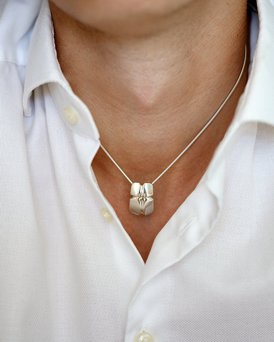 ARN Kors halsband i silver, buret på modell