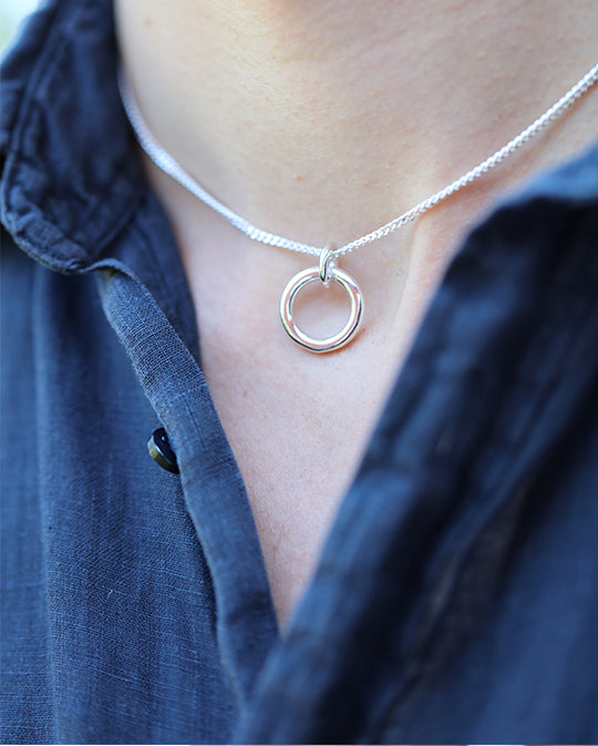 I HAMN halsband i silver mot mörk skjorta