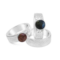 Two textured silver rings with round cabochon stones in bezels red brown and dark blue