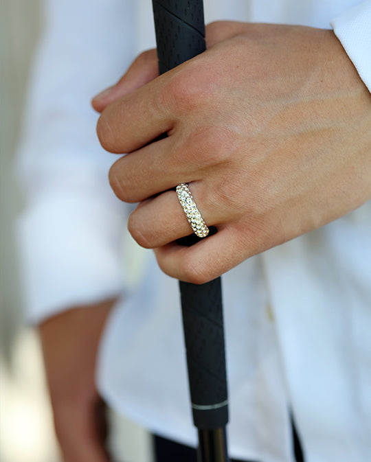 GOLF ring i silver på hand som håller ett golfgrepp