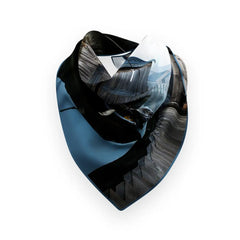 Blue teal Hemma Hamn silk scarf tied in a knot over a white knit sweater