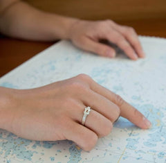 Close up of a hand wearing a silver RÅBANDSKNOP ring on the ring finger