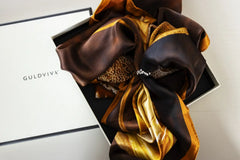 Celebrate silk scarf in brown and gold tones tied in a white gift box.