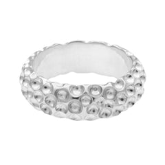 Närbild av hand med silver golfring på fingret när personen greppar en slips