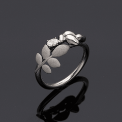 EVA 18K ring featuring a central diamond and leaf accents along the band