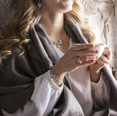 Modell bär EVA halsband i silver med bladformade berlocker och kubisk zirkon