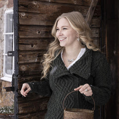 Smiling woman wearing the EVA necklace with potato leaf motif and cubic zirconia pendant along with matching earrings